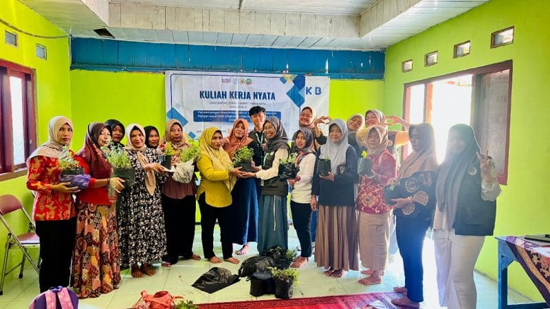 Mahasiswa KKN UNS berfoto bersama ibu-ibu PKK Desa Getas, Blora, sambil menunjukkan polybag berisi benih tanaman. Kegiatan ini merupakan bagian dari program
