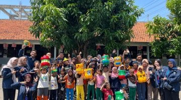 Mahasiswa KKN Universitas PGRI Semarang (UPGRIS) Kelompok 45 berfoto bersama siswa SDN 1 Karangsari, Kendal. Mereka berkolaborasi dalam program pembuatan tempat sampah dari galon bekas yang bertujuan untuk menumbuhkan kesadaran akan pentingnya menjaga kebersihan lingkungan sejak dini.