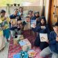 Mahasiswa KKN Tematik Universitas PGRI Semarang (UPGRIS) Kelompok 21 berfoto bersama anak-anak Desa Kalisidi di depan posko KKN yang dijuluki “Rumah Belajar”. Kegiatan ini merupakan program Perpustakaan Keliling yang bertujuan menumbuhkan minat baca dan literasi anak sejak usia dini.