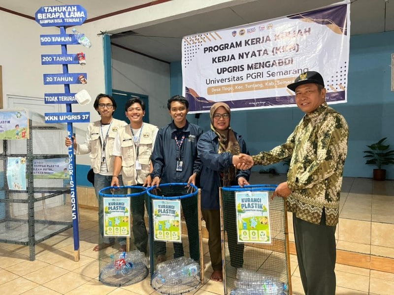 Mahasiswa KKN UPGRIS Kelompok 37 sedang menyerahkan tempat sampah pilah dengan label “Kurangi Plastik, Selamatkan Bumi” kepada perwakilan Pemerintah Desa Tlogo. Penyerahan ini merupakan tindak lanjut dari sosialisasi bank sampah botol plastik dan pembuatan ecobrick, yang menjadi simbol komitmen mahasiswa dalam mendukung pengelolaan sampah berkelanjutan di desa.
