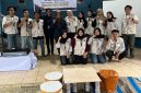 Mahasiswa KKN UPGRIS Kelompok 37 berfoto bersama warga Desa Tlogo di depan meja dan kursi kecil hasil inovasi mereka yang diolah dari limbah botol plastik (ecobrick). Kegiatan ini merupakan bagian dari program pengelolaan dan pemanfaatan limbah sampah yang bertujuan memberikan solusi kreatif dan edukatif untuk lingkungan.