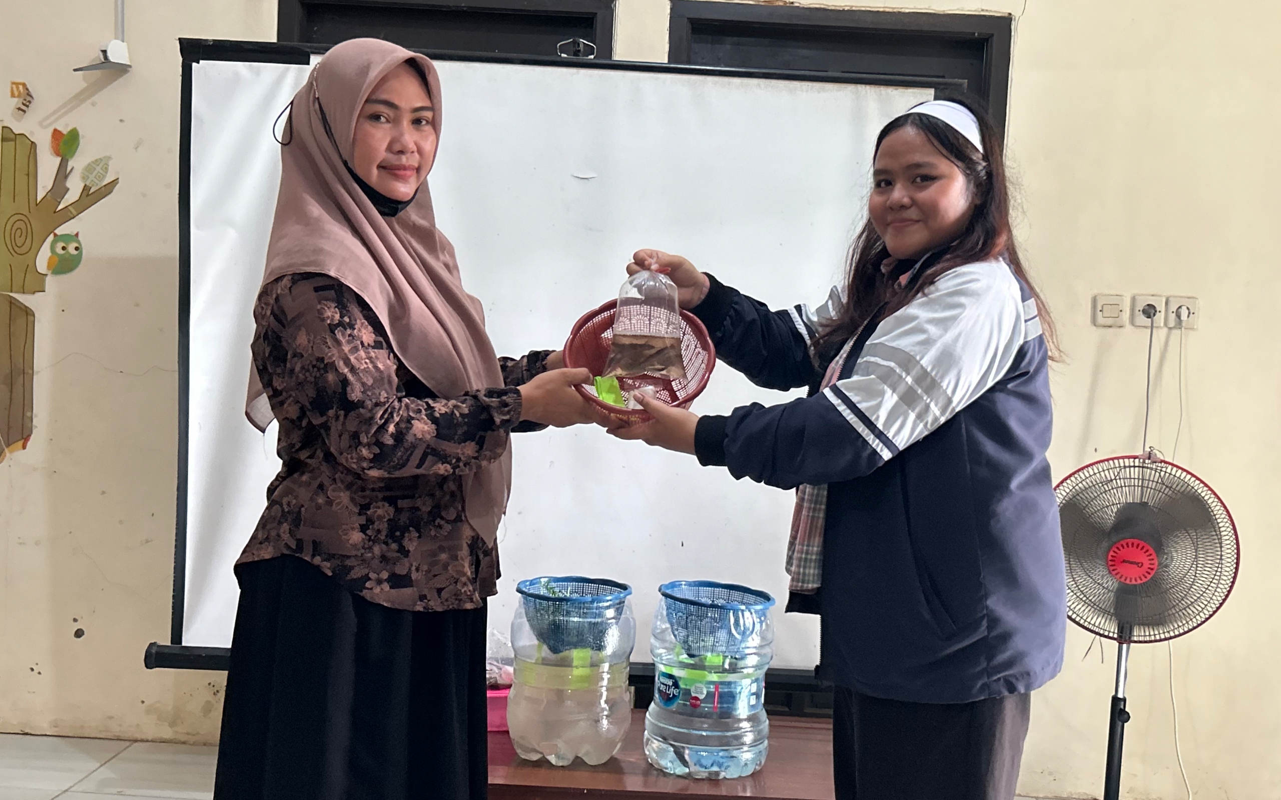 Penyerahan bingkisan berupa bibit lele dan bibit kangkung kepada ibu PKK